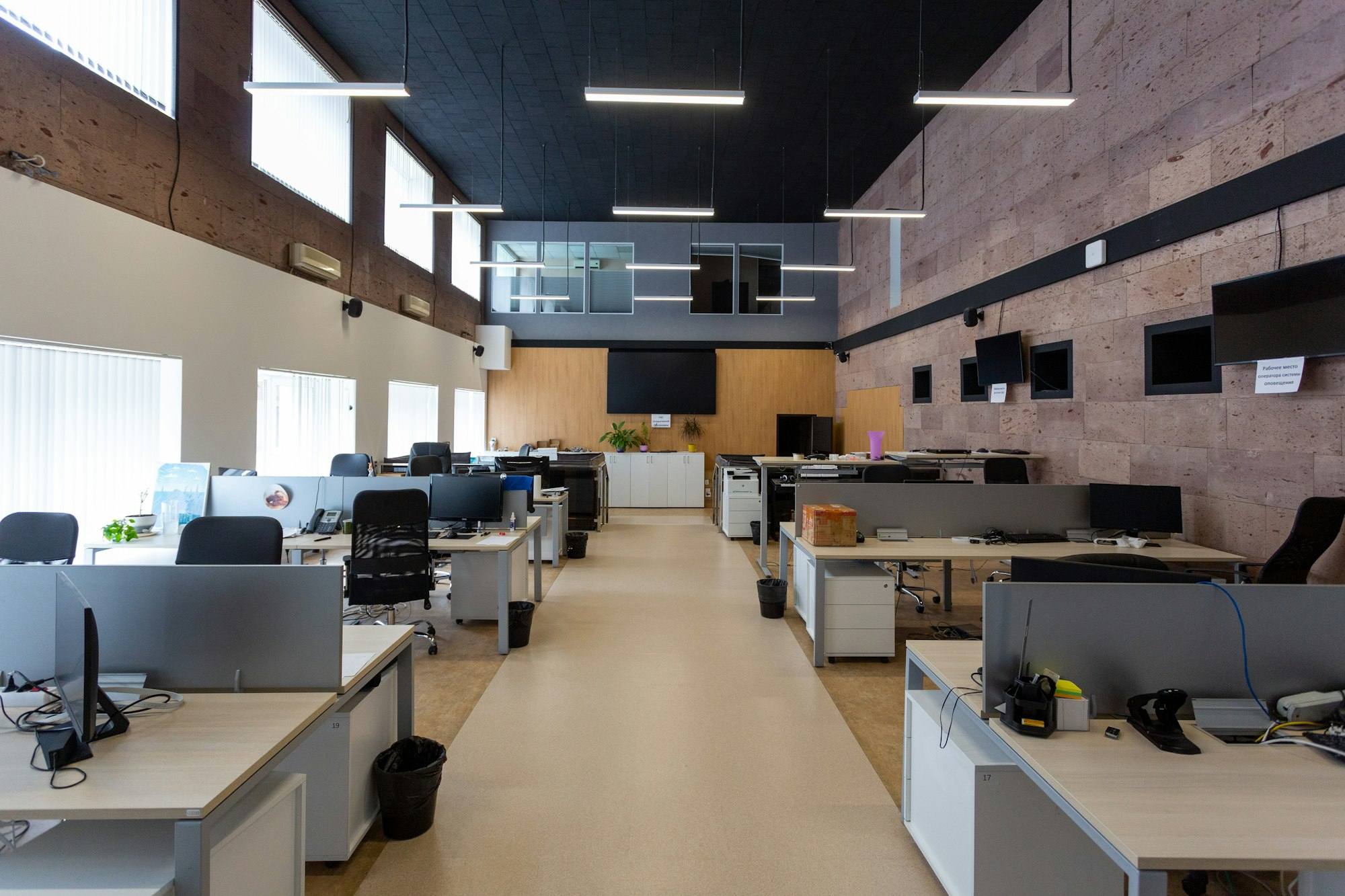 Grand plateau open space avec bureaux alignés et mezzanine vitrée, bureaux de Saint-Brieuc