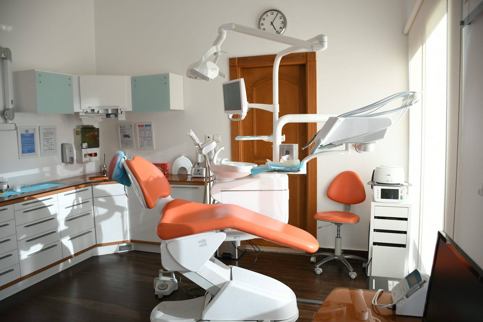 Fauteuil de soin technique orange sous un éclairage scialytique, cabinet de podologie agencé à Rennes