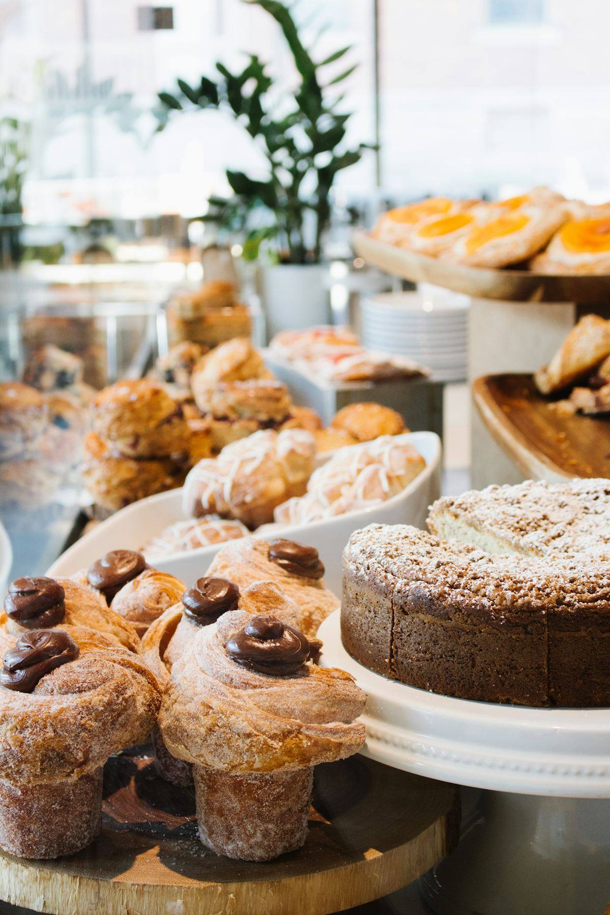 Présentoir en bois avec muffins, viennoiseries et gâteau entier, café-boulangerie agencé à Vitré