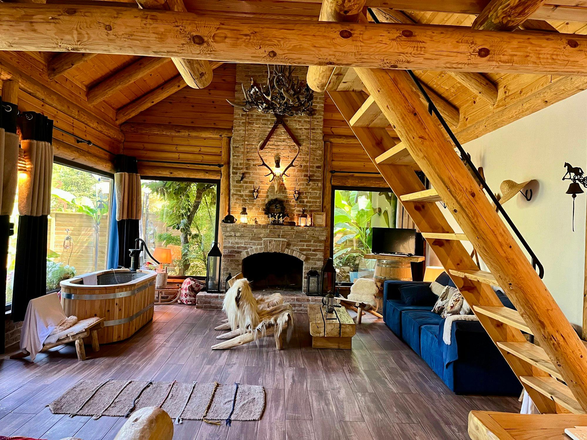 Séjour en rondins de bois avec cheminée en pierre, bain nordique et mezzanine, gîte près de Vitré