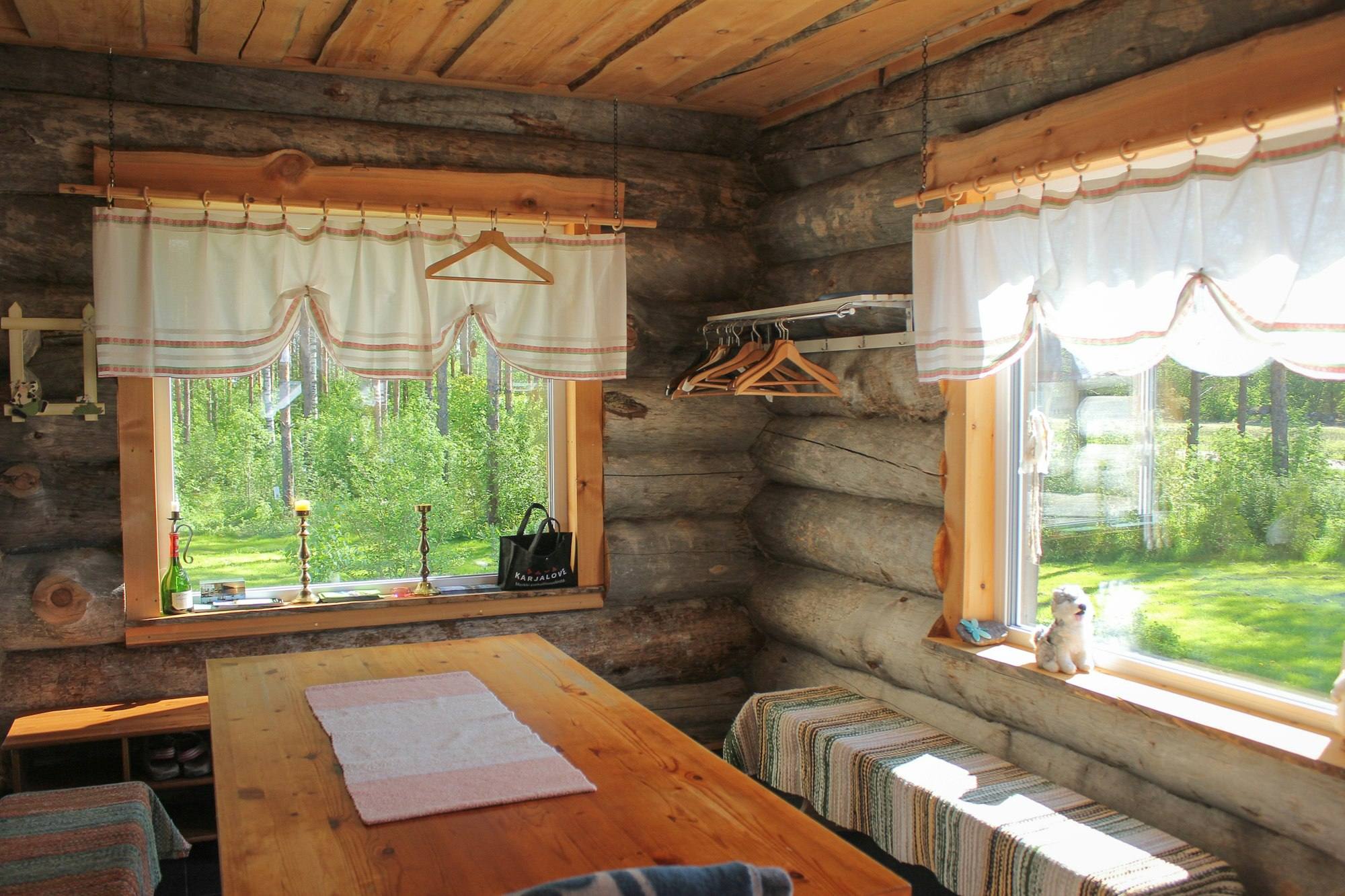 Salle à manger en rondins avec table en bois et vue sur la forêt, gîte près de Vitré