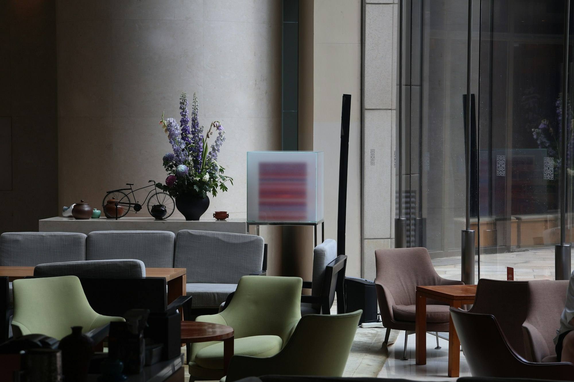 Salon lounge en fin de journée avec fauteuils verts et bouquet de fleurs, hôtel de Saint-Malo