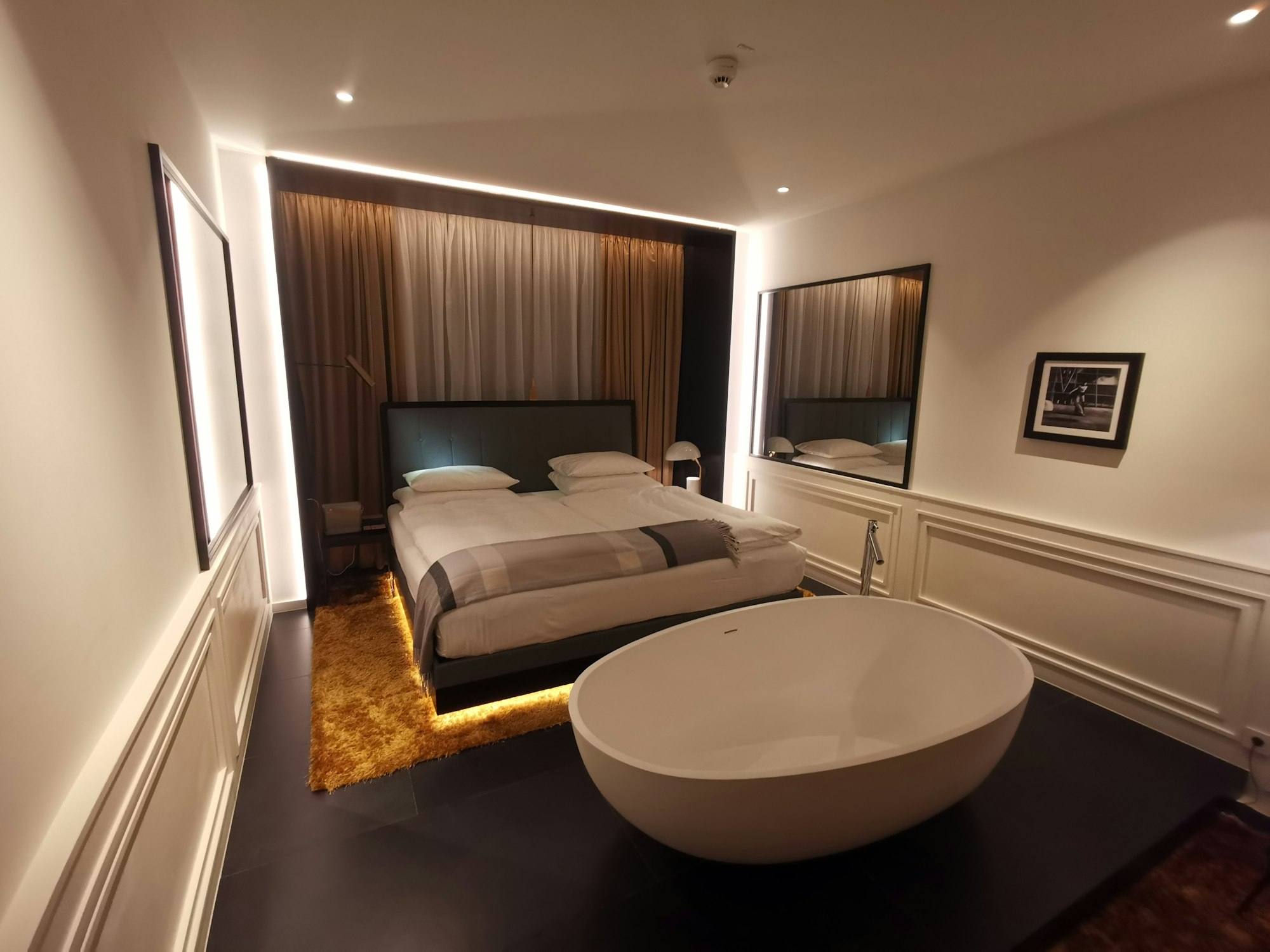 Chambre avec baignoire îlot ovale placée face au lit, hôtel du centre de Saint-Malo