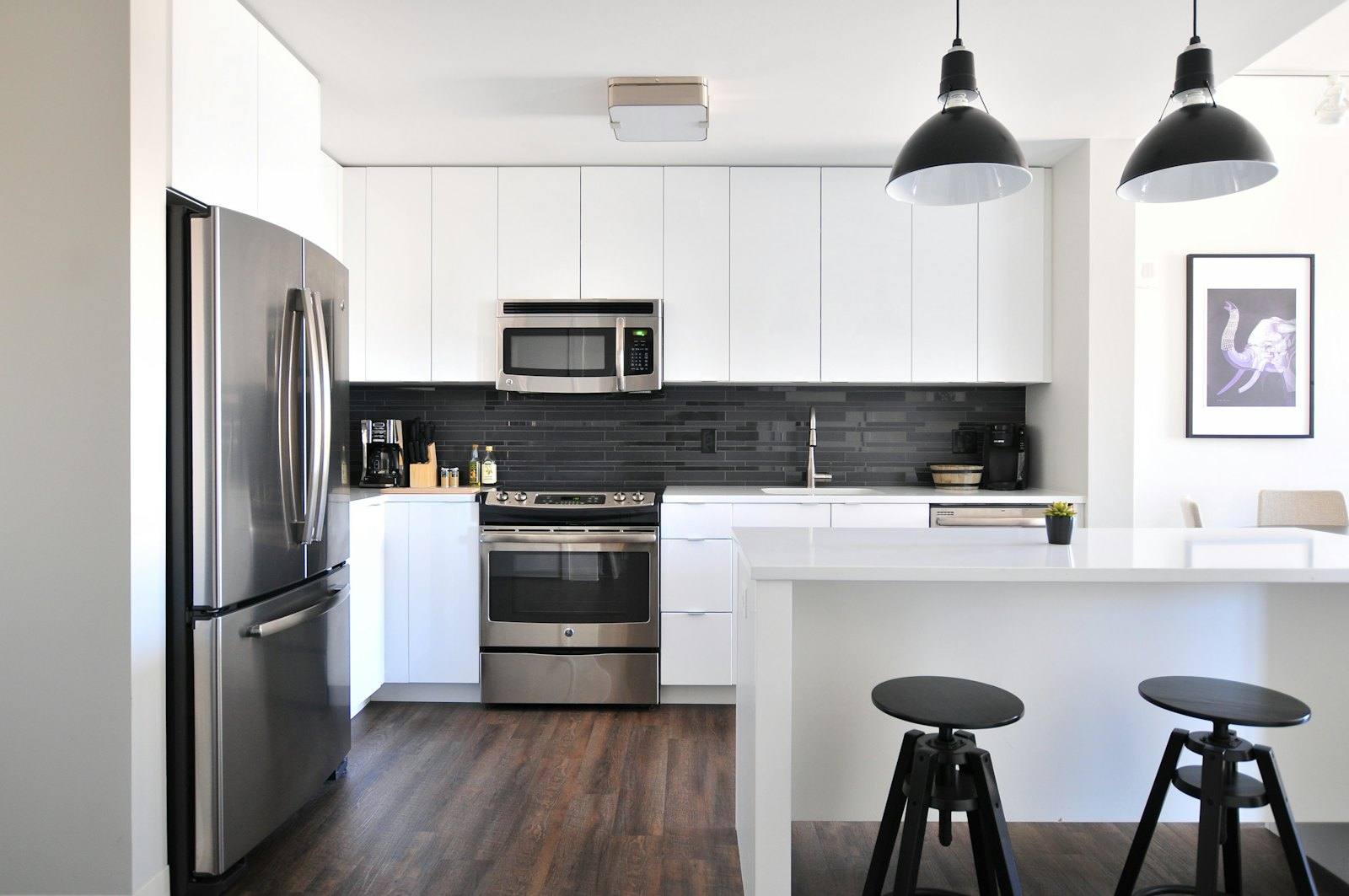 Vue rapprochée de l'îlot de cuisine avec plaque de cuisson et suspensions noires, loft à Rennes
