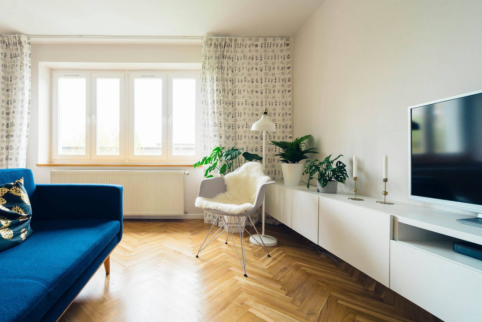 Salon avec canapé bleu marine et parquet à chevrons ancien, loft rennais réaménagé au cœur de Rennes