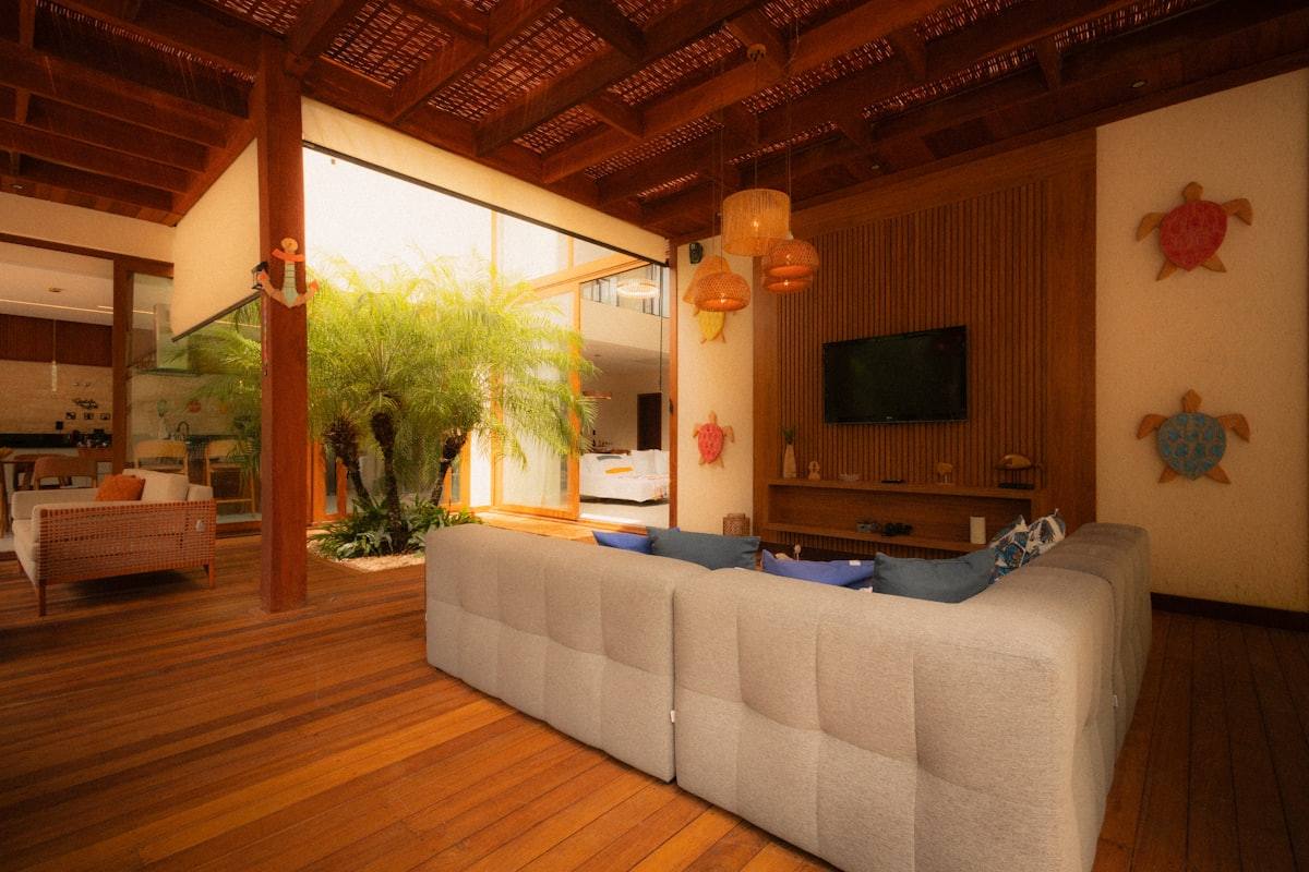 Vue élargie du salon avec canapé modulable et écran mural, villa face à la mer à Dinard